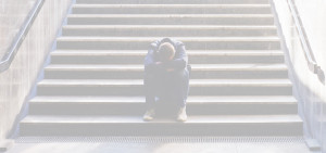 Dejected man sitting on stairs, filtered